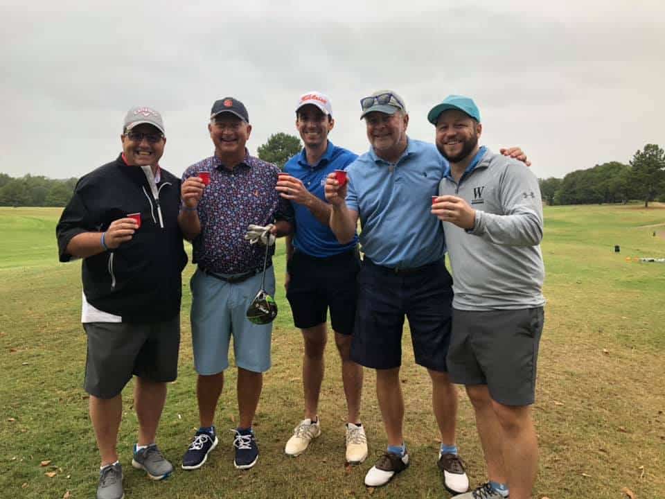 five men in golfing attire smiling