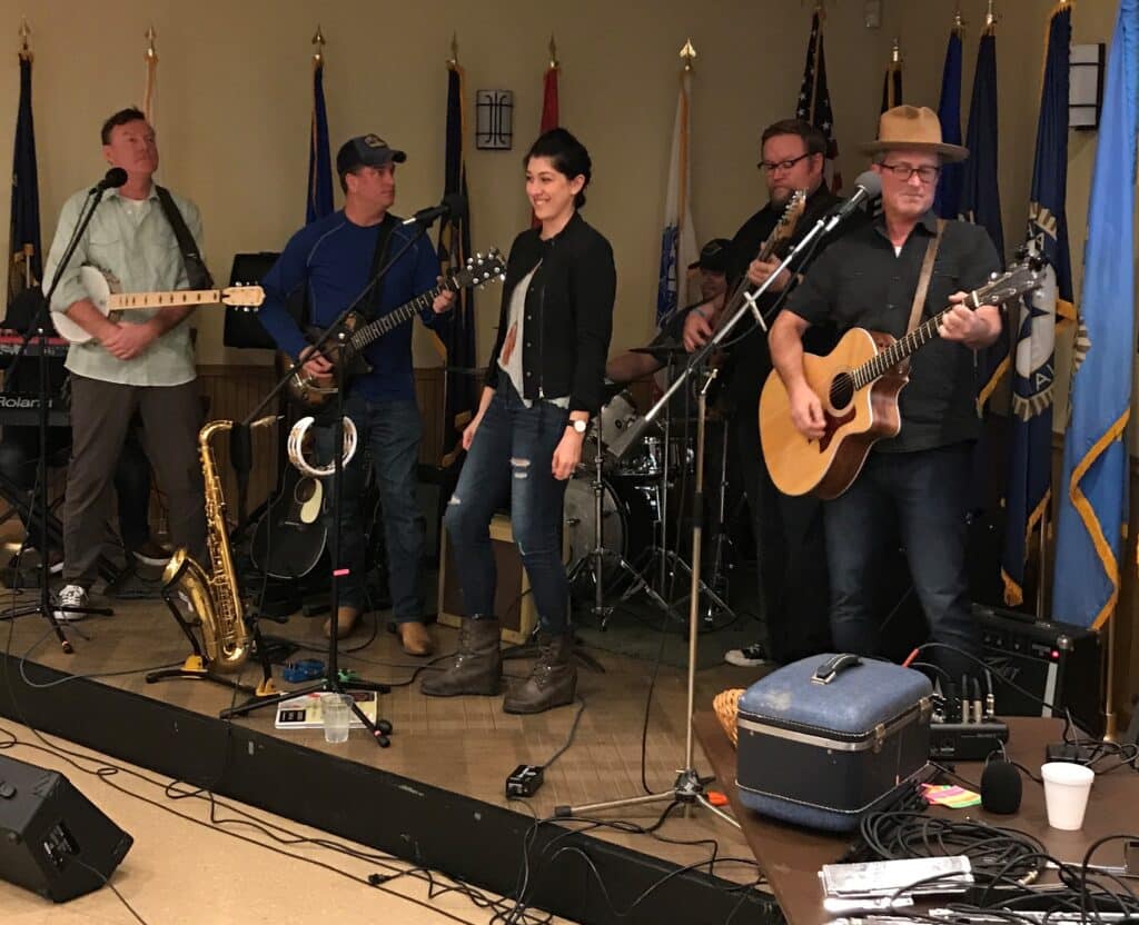 five musicians playing instruments on a stage